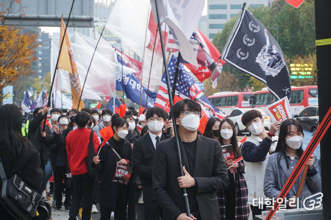 참여자들이 행진 과정에서 사회자의 발언을 경청하고 있다.