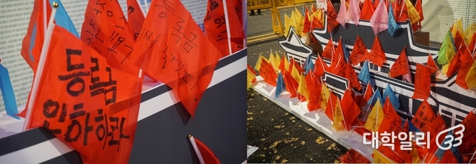 청와대 앞 집회에서 대학생들의 요구가 담긴 깃발을 청와대 모형에 꽂고 있다.