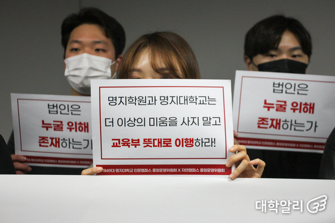 '법인은 누굴 위해 존재하는가', '학교와 법인은 더이상 미움을 사지 말고 교육부 뜻대로 이행하라'는 피켓을 들고 있는 학생들.