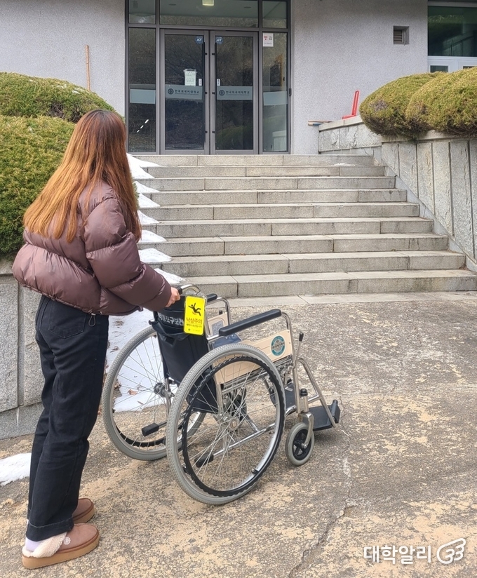 경사로가 없어 건물에 진입하지 못하고 멈춰 선 휠체어 / 사진 = 오기영 기자