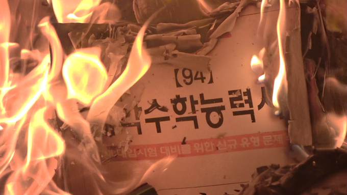 <수능 창시자; 한국 교육의 프랑켄슈타인> 스틸컷, 대학수학능력시험 문제제가 불타고 있다. (사진=무빙모먼츠 스튜디오)