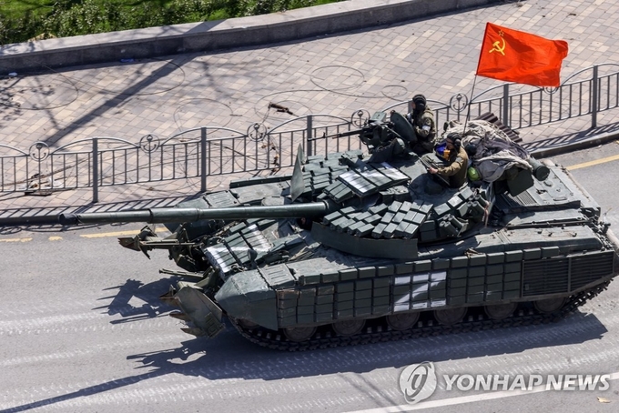 A tank of pro-Russian separatists bearing the Soviet flag races through the streets of Mariupol, a southern port city in Ukraine. (Photo by Yonhap News)