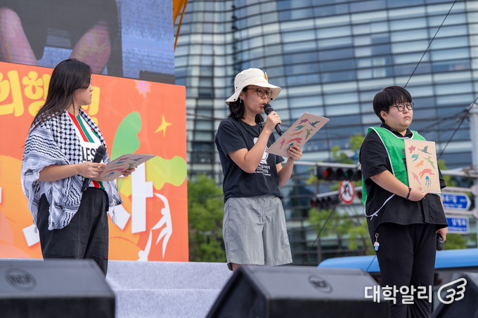 27일 오후 서울 종로구 광화문 앞에서 '927기후정의행진'이 열린 모습. 이이자희 국립공원을지키는시민의모임 활동가, 권영은 반올림 활동가, 한나 팔레스타인긴급행동 활동가가 본집회에서 발언하고 있다. (사진=차종관)