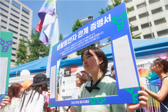 2024년 서울퀴어퍼레이드에서 ‘생활동반자 관계 증명서’ 판넬을 들고 있는 청년·대학생위원회 회원